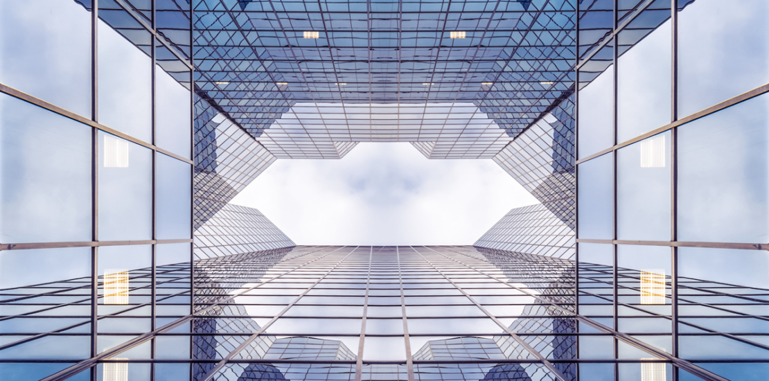Glass office towers seen from below illustrating the governance gap in mid-sized Saudi companies, Clarion Consulting