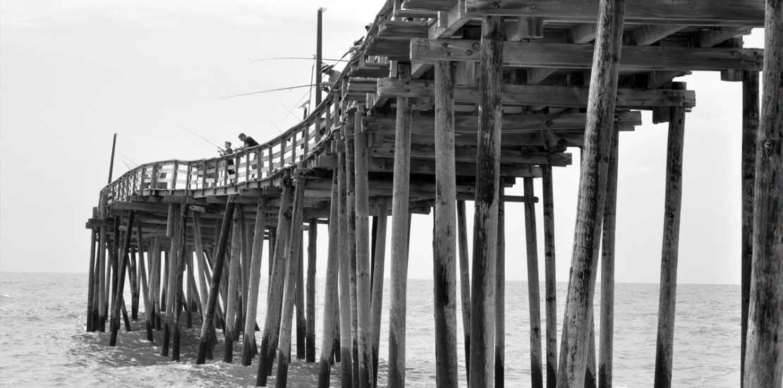 Wooden pier on pilings illustrating the unstated assumptions beneath every business strategy, Clarion Consulting