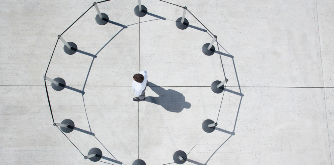 Person alone inside a ring of barrier posts showing capability constrained by organizational design, Clarion Consulting