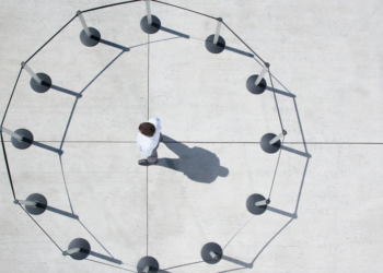 Person alone inside a ring of barrier posts showing capability constrained by organizational design, Clarion Consulting